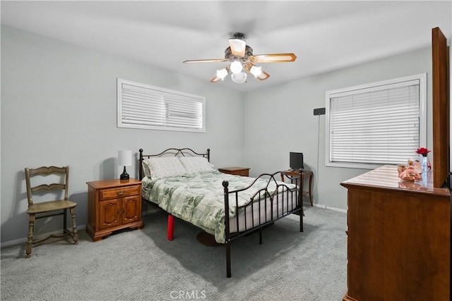 bedroom with light carpet, ceiling fan, and baseboards