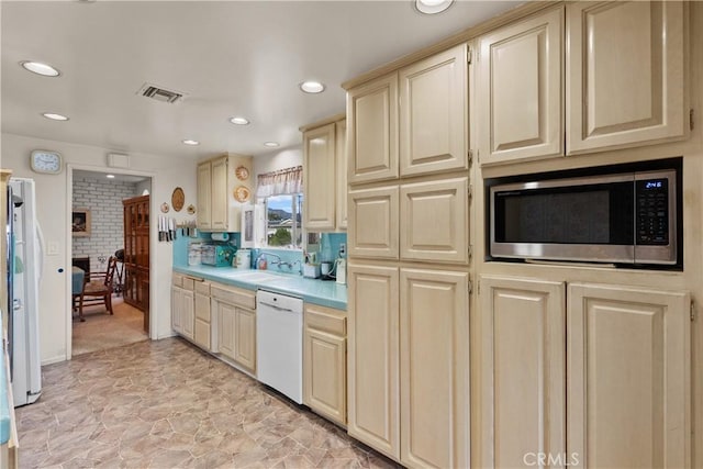 kitchen with visible vents, light countertops, freestanding refrigerator, dishwasher, and stainless steel microwave