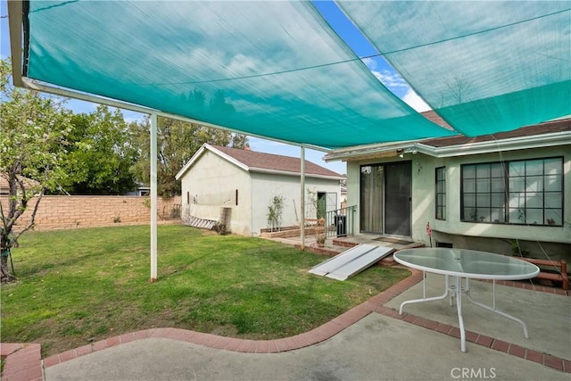 view of yard featuring an outbuilding, a patio, and fence