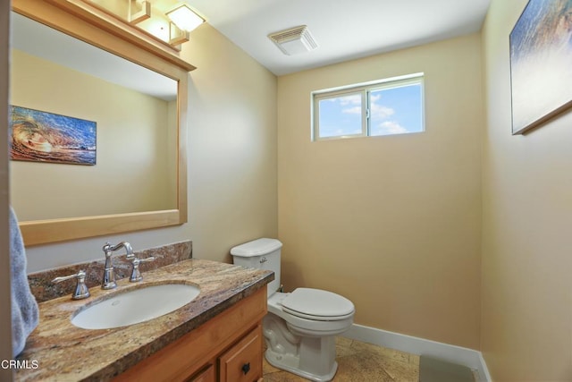 half bathroom with vanity, toilet, baseboards, and visible vents