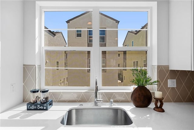 interior details featuring light countertops, a sink, and decorative backsplash