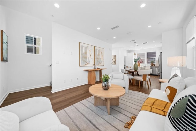 living room with baseboards, wood finished floors, visible vents, and recessed lighting