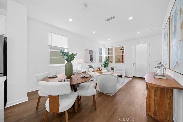 dining space featuring baseboards, wood finished floors, visible vents, and recessed lighting