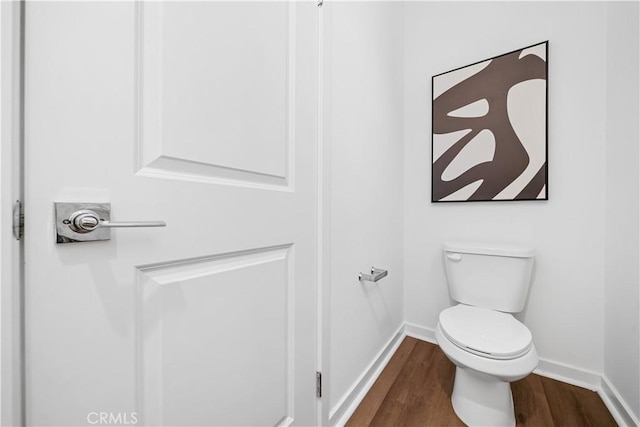 bathroom featuring toilet, baseboards, and wood finished floors