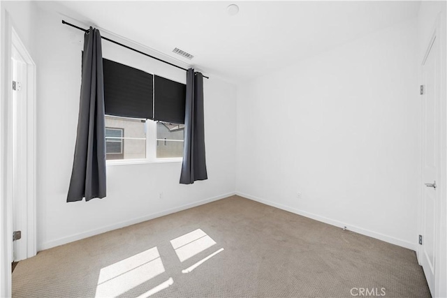 carpeted empty room with baseboards and visible vents