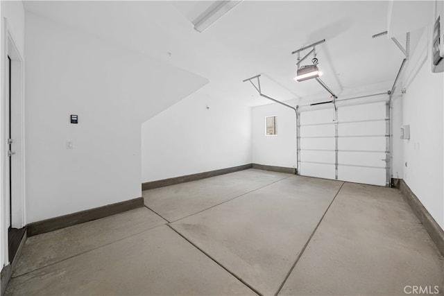 garage featuring a garage door opener and baseboards