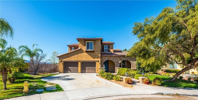 mediterranean / spanish house featuring stucco siding, concrete driveway, a front yard, a garage, and stone siding