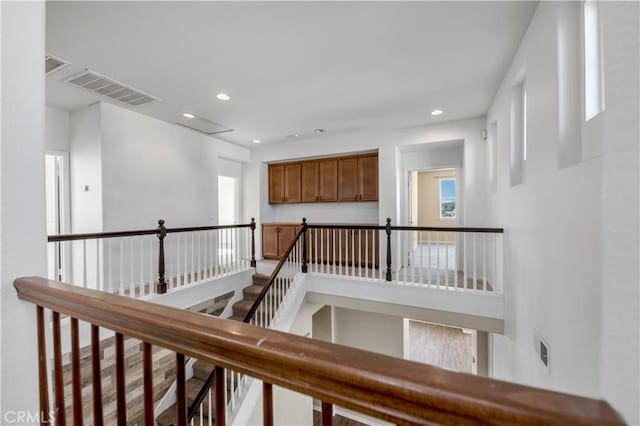 hall with recessed lighting, visible vents, and an upstairs landing