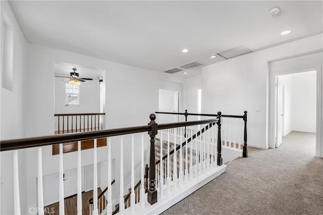 hall with carpet, an upstairs landing, and recessed lighting