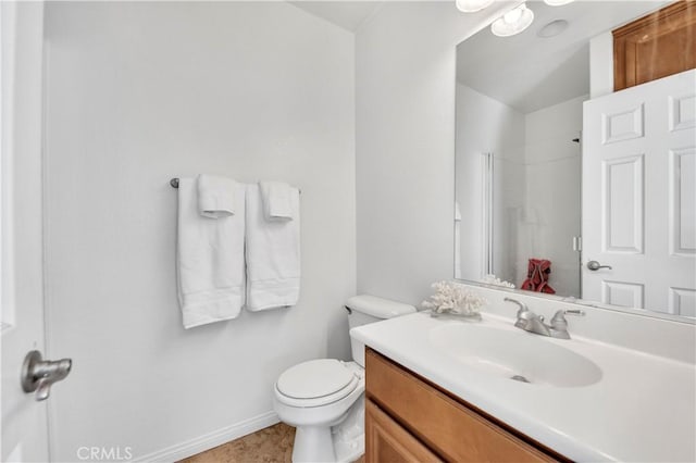 bathroom with toilet, baseboards, a shower, and vanity