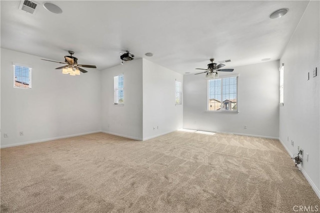 unfurnished room featuring a ceiling fan, a healthy amount of sunlight, visible vents, and light carpet