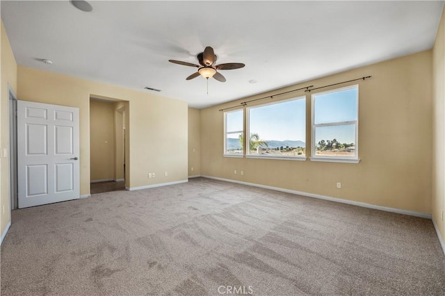 unfurnished bedroom with a ceiling fan, carpet, visible vents, and baseboards