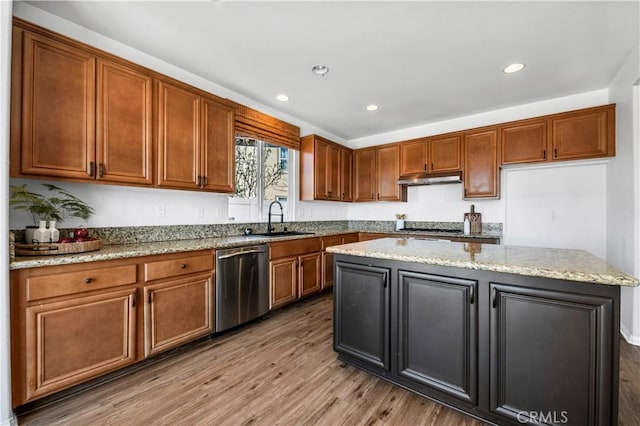 kitchen with a center island, a sink, wood finished floors, dishwasher, and under cabinet range hood