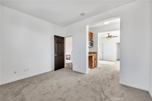 unfurnished bedroom featuring light carpet and baseboards