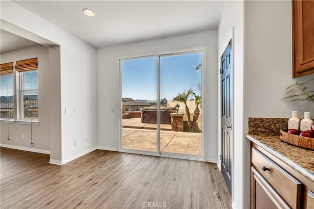 entryway with light wood-type flooring, baseboards, and recessed lighting