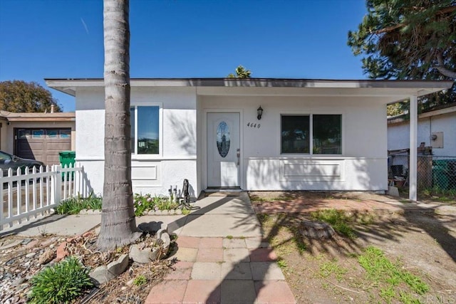 view of front of home featuring fence and stucco siding