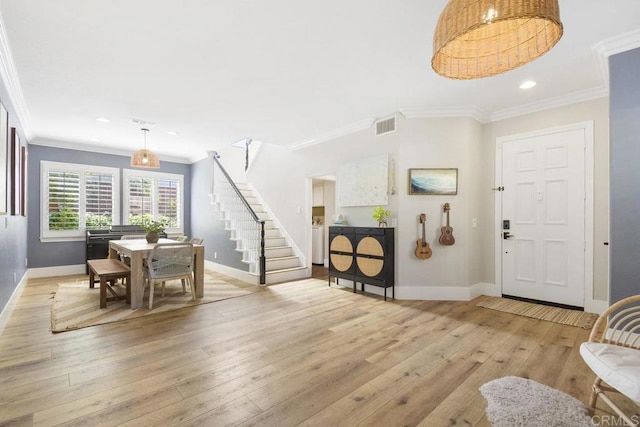 entrance foyer featuring visible vents, crown molding, baseboards, stairway, and hardwood / wood-style flooring