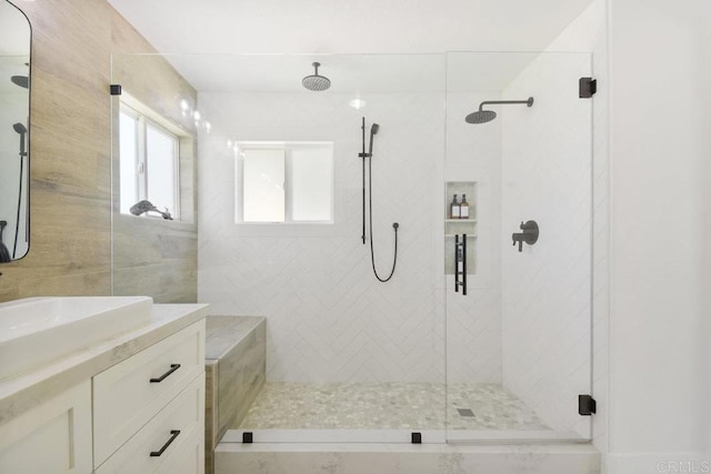 full bathroom featuring tiled shower and vanity