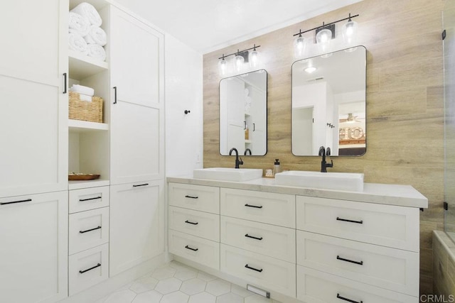 full bathroom featuring tile patterned flooring, tile walls, double vanity, and a sink