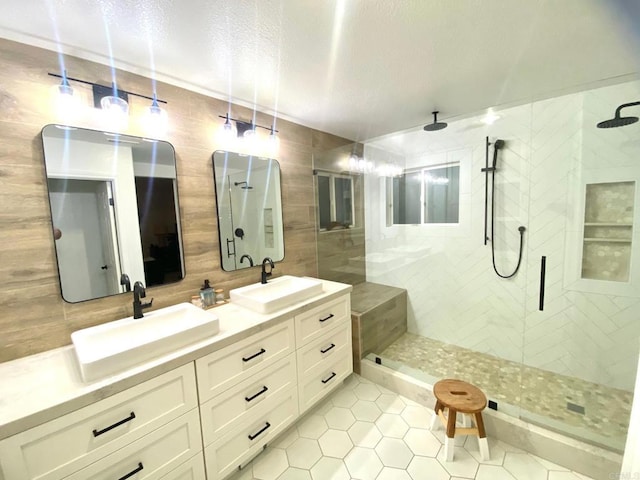 bathroom with tasteful backsplash, a stall shower, and a sink