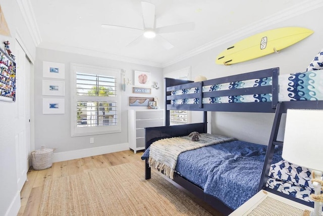 bedroom with ceiling fan, crown molding, baseboards, and wood finished floors