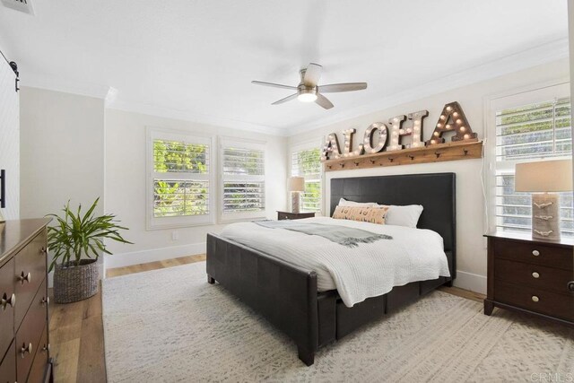 bedroom featuring visible vents, baseboards, light wood-style floors, and crown molding