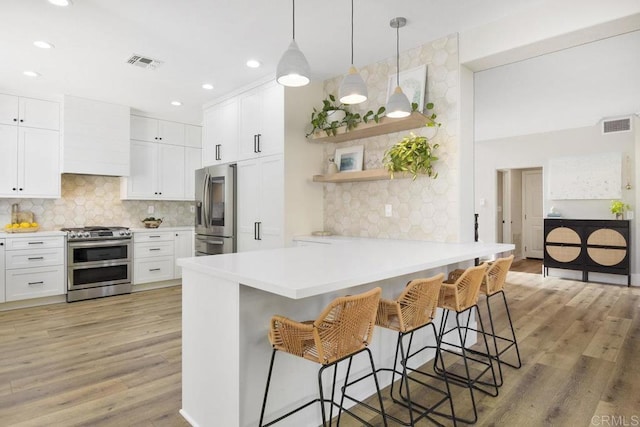 kitchen with visible vents, appliances with stainless steel finishes, a breakfast bar, and decorative backsplash