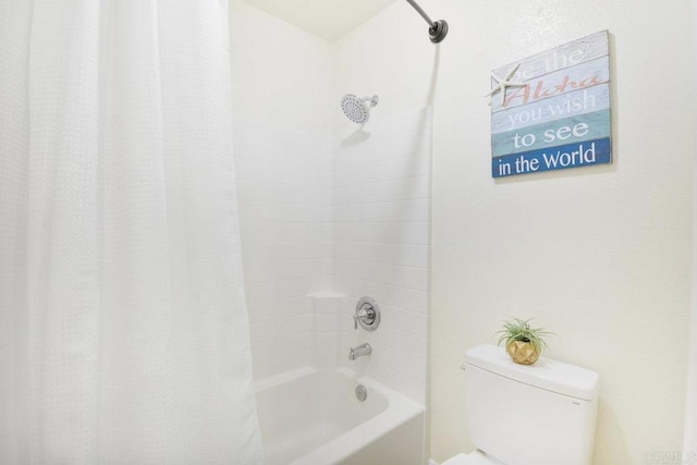 bathroom with shower / bath combination with curtain and toilet