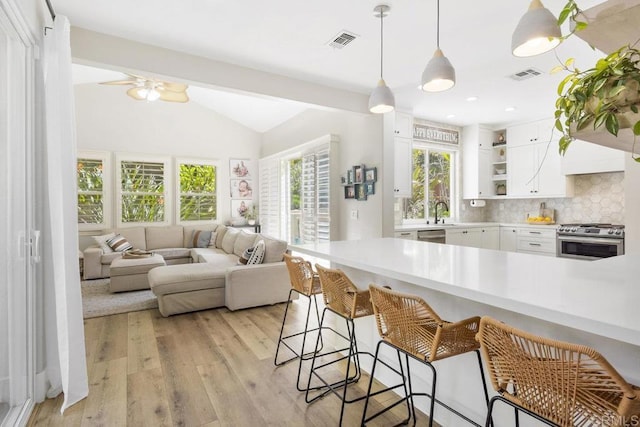 kitchen featuring visible vents, appliances with stainless steel finishes, open floor plan, and open shelves