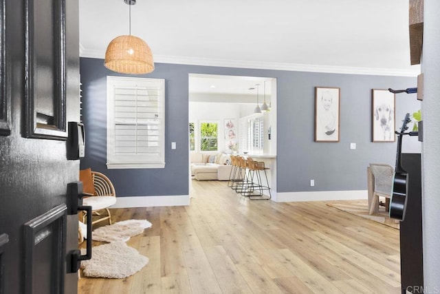 entryway with crown molding, baseboards, and wood-type flooring