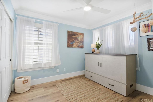 interior space featuring crown molding, baseboards, and wood finished floors