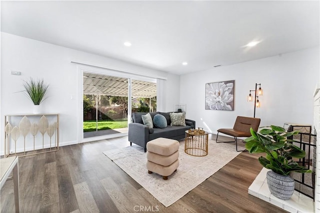 living area with visible vents, baseboards, wood finished floors, and recessed lighting