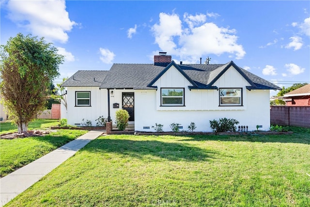 view of front of home featuring fence, roof with shingles, crawl space, a front lawn, and a chimney