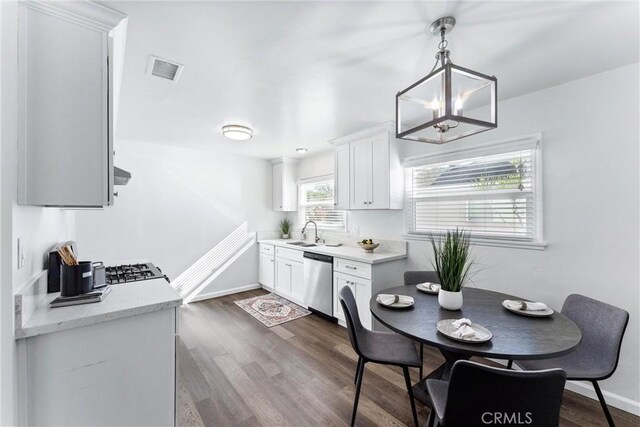 kitchen with visible vents, dark wood finished floors, dishwasher, white cabinetry, and a sink