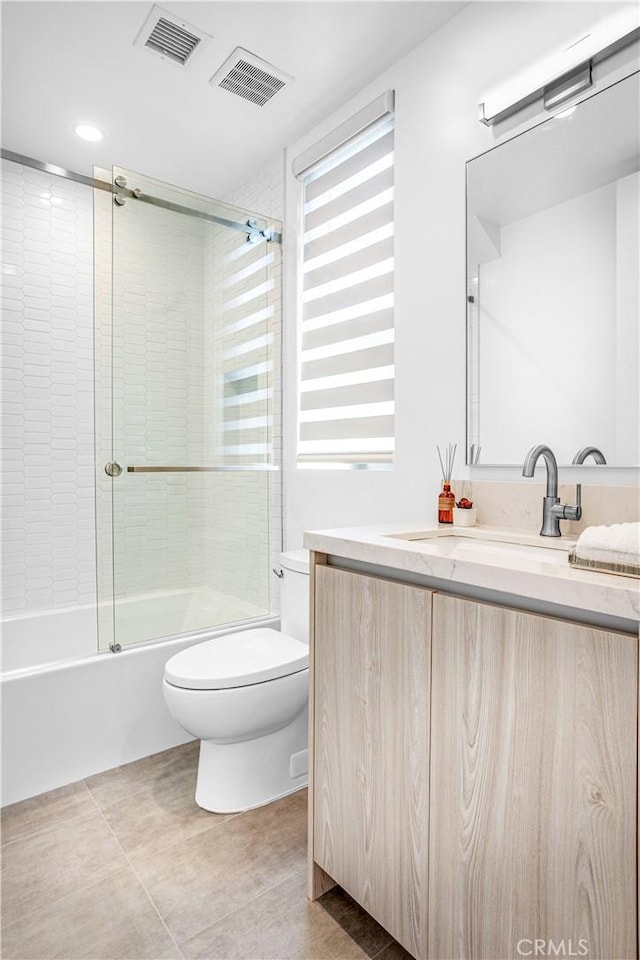 full bath featuring toilet, enclosed tub / shower combo, visible vents, and vanity