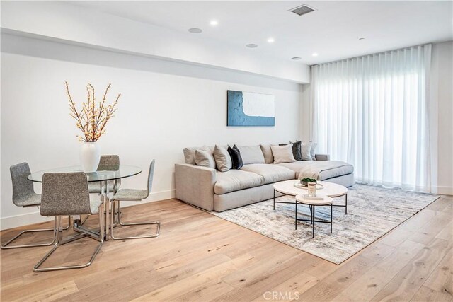 living room featuring recessed lighting, visible vents, baseboards, and wood finished floors