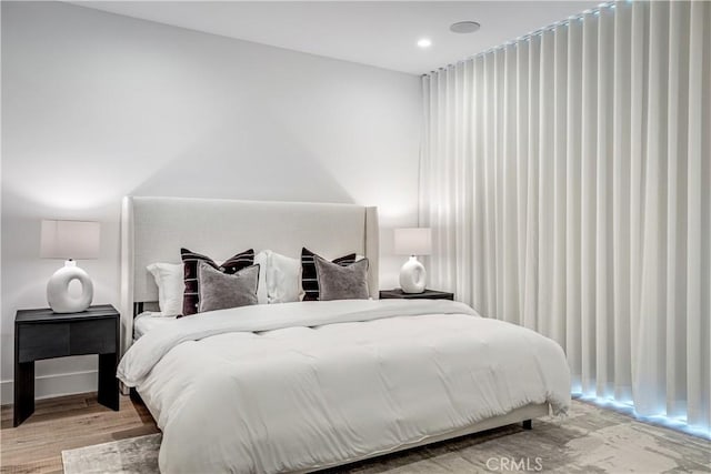 bedroom with recessed lighting and wood finished floors