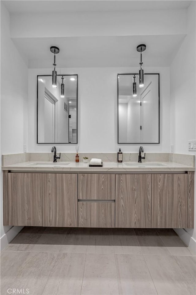 bathroom featuring double vanity, a sink, and tile patterned floors