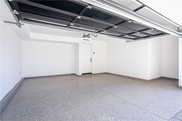 garage with a garage door opener and baseboards