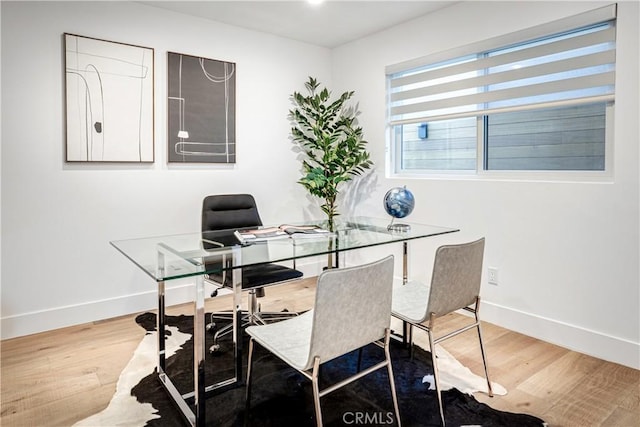 dining space featuring baseboards and wood finished floors