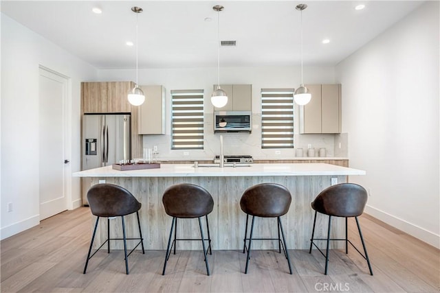 kitchen featuring appliances with stainless steel finishes, light countertops, visible vents, and tasteful backsplash