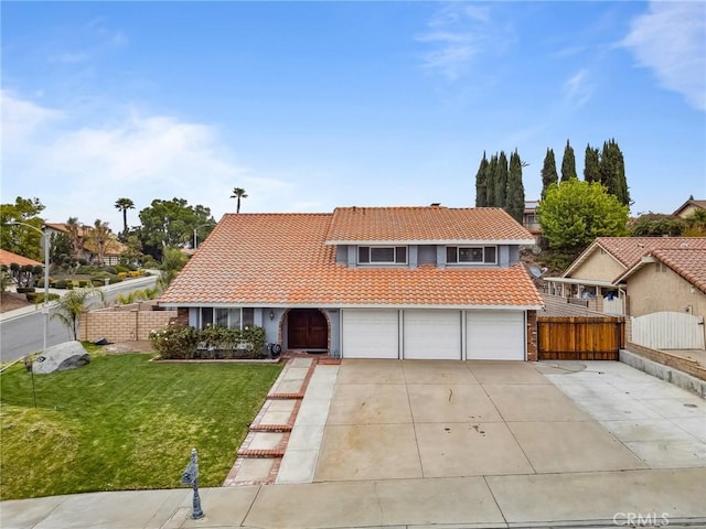 view of front of home featuring a tile roof, fence, a garage, driveway, and a front lawn