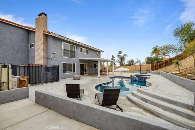 view of swimming pool featuring a patio area, a fenced backyard, and a pool with connected hot tub