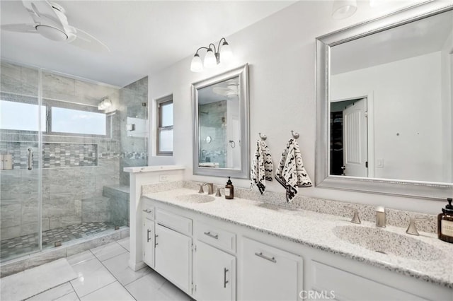 full bathroom featuring double vanity, a shower stall, and a sink