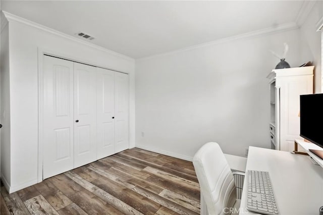 unfurnished office with visible vents, crown molding, and wood finished floors