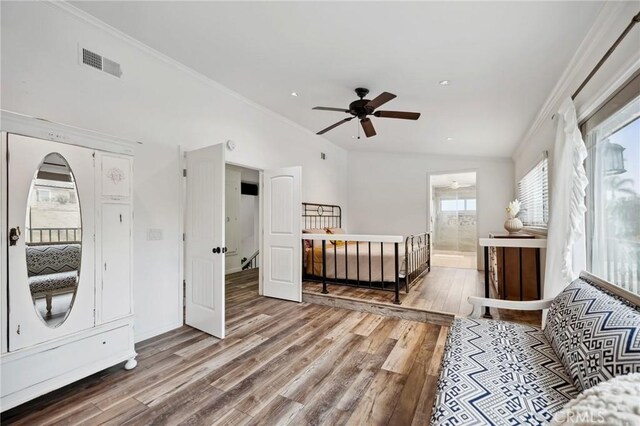 bedroom featuring connected bathroom, wood finished floors, visible vents, baseboards, and crown molding