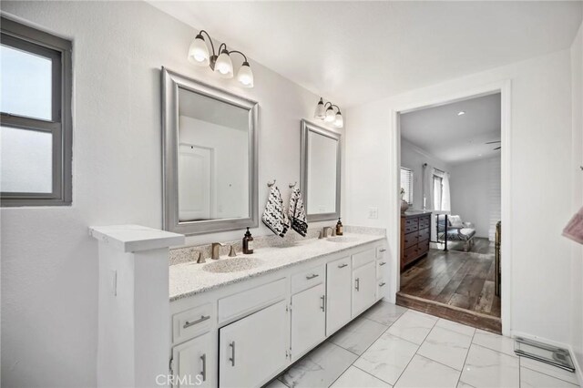 bathroom with double vanity, marble finish floor, and a sink