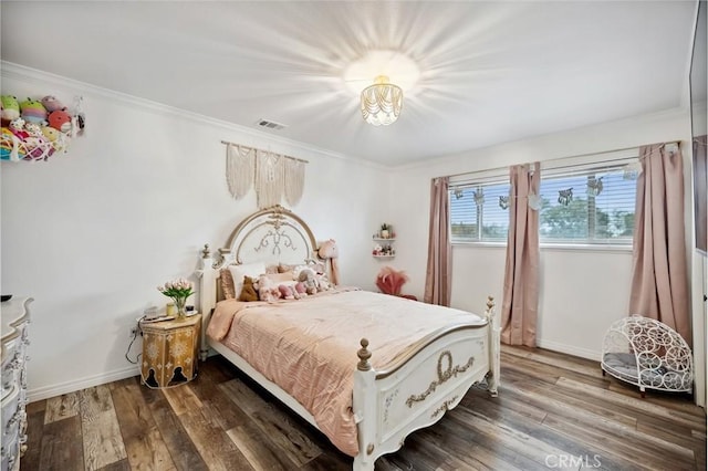 bedroom featuring visible vents, crown molding, baseboards, and wood finished floors