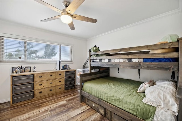 bedroom featuring ornamental molding, a ceiling fan, baseboards, and wood finished floors