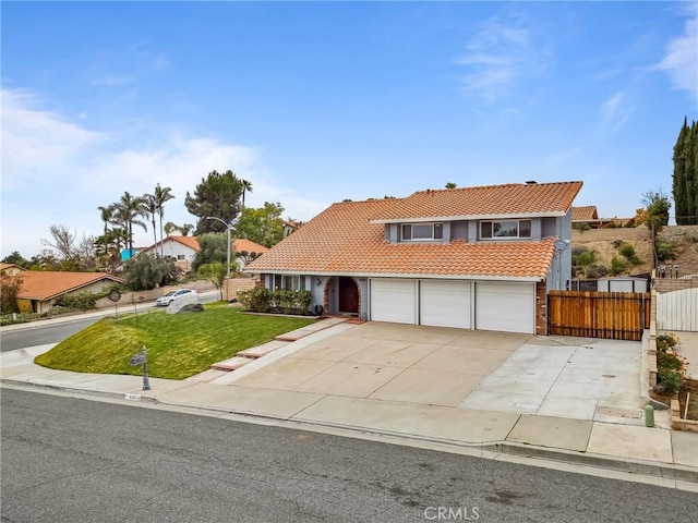 view of front of house featuring an attached garage, fence, driveway, a tiled roof, and a front lawn